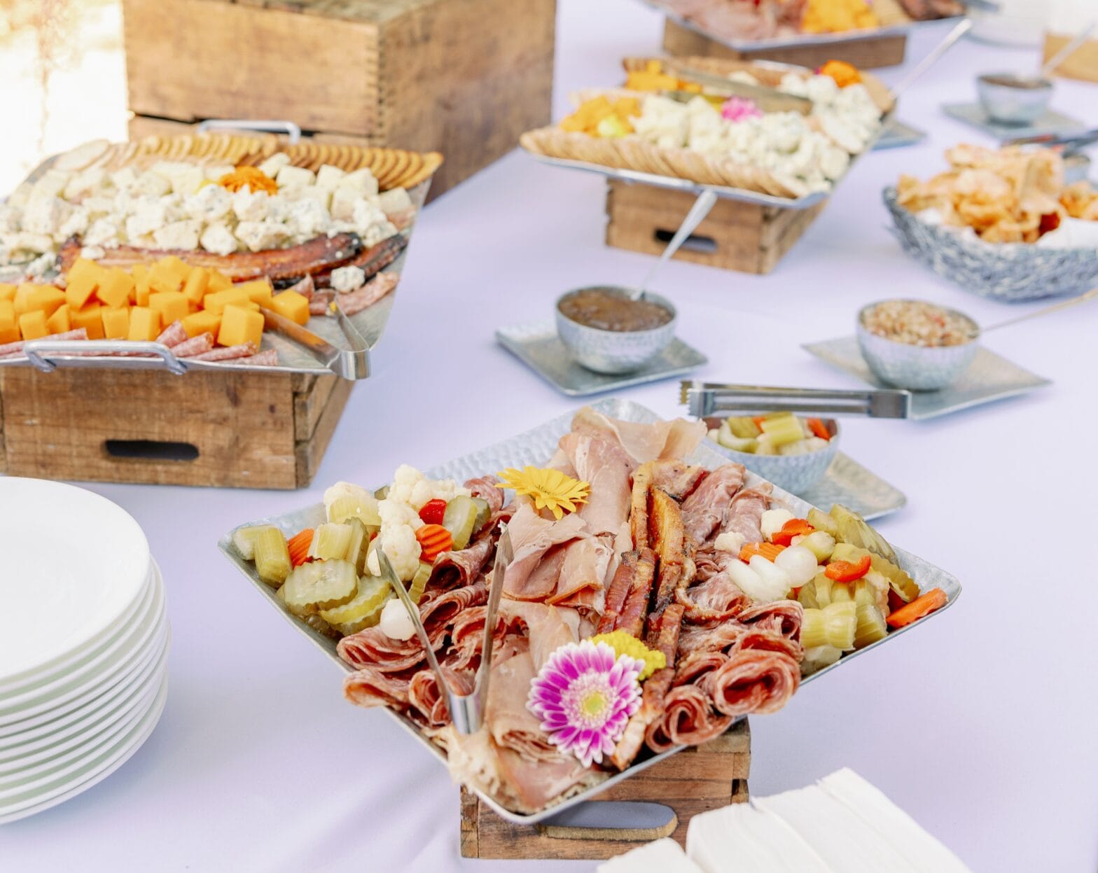 Close up of table with meats and cheeses on trays.